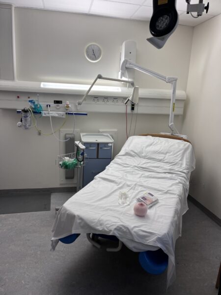 An empty hospital bed, with midwifery materials on the bed.