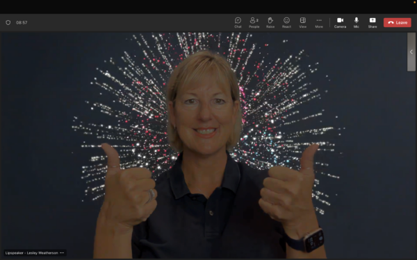 A woman holding two thumbs up. A fireworks animation appear s behind the woman.